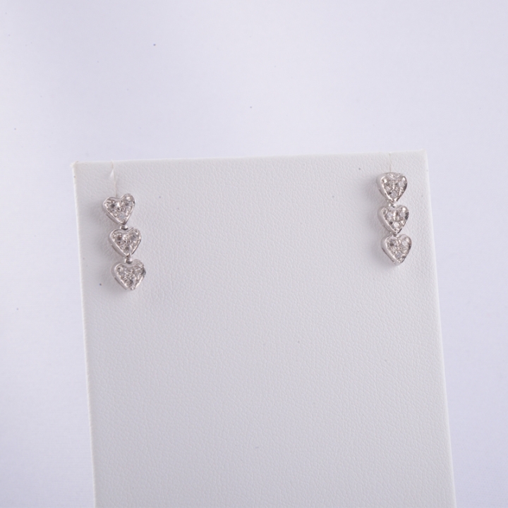 Orecchini trilogy a cuori, a lobo, in oro bianco 18 kt con duraliti taglio brillante.