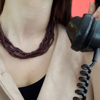 Collana da donna, in granato a 7 fili, chiusura in argento dorato. Lunghezza 48 cm.