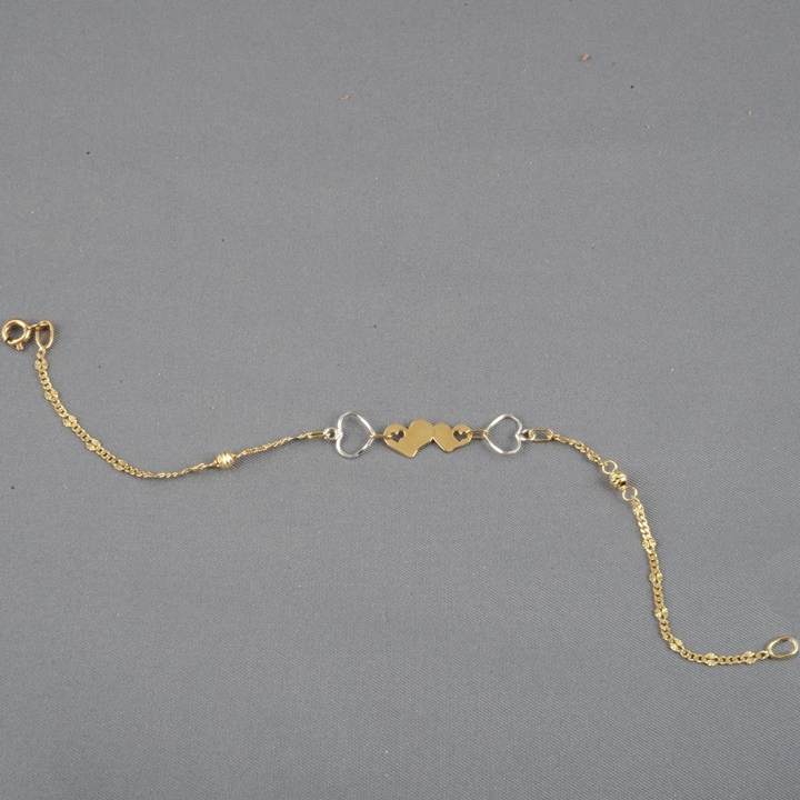Braccialetto donna realizzato interamente in oro 18kt. Charms Cuori in oro giallo e bianco