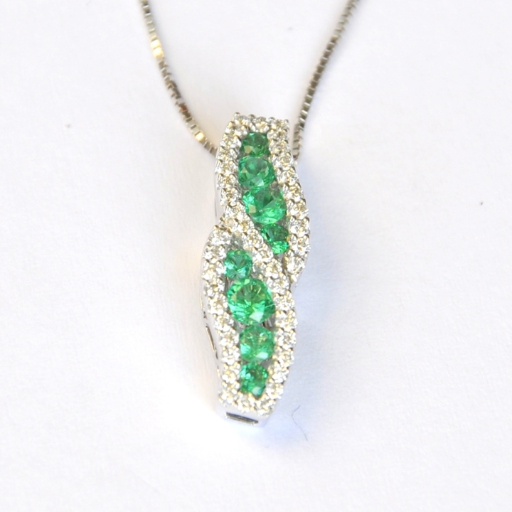 Ciondolo fantasia in oro bianco 18 kt, impreziosito da smeraldi naturali ct. 0.49 e contorno in brillanti 0.24 ct GVS.